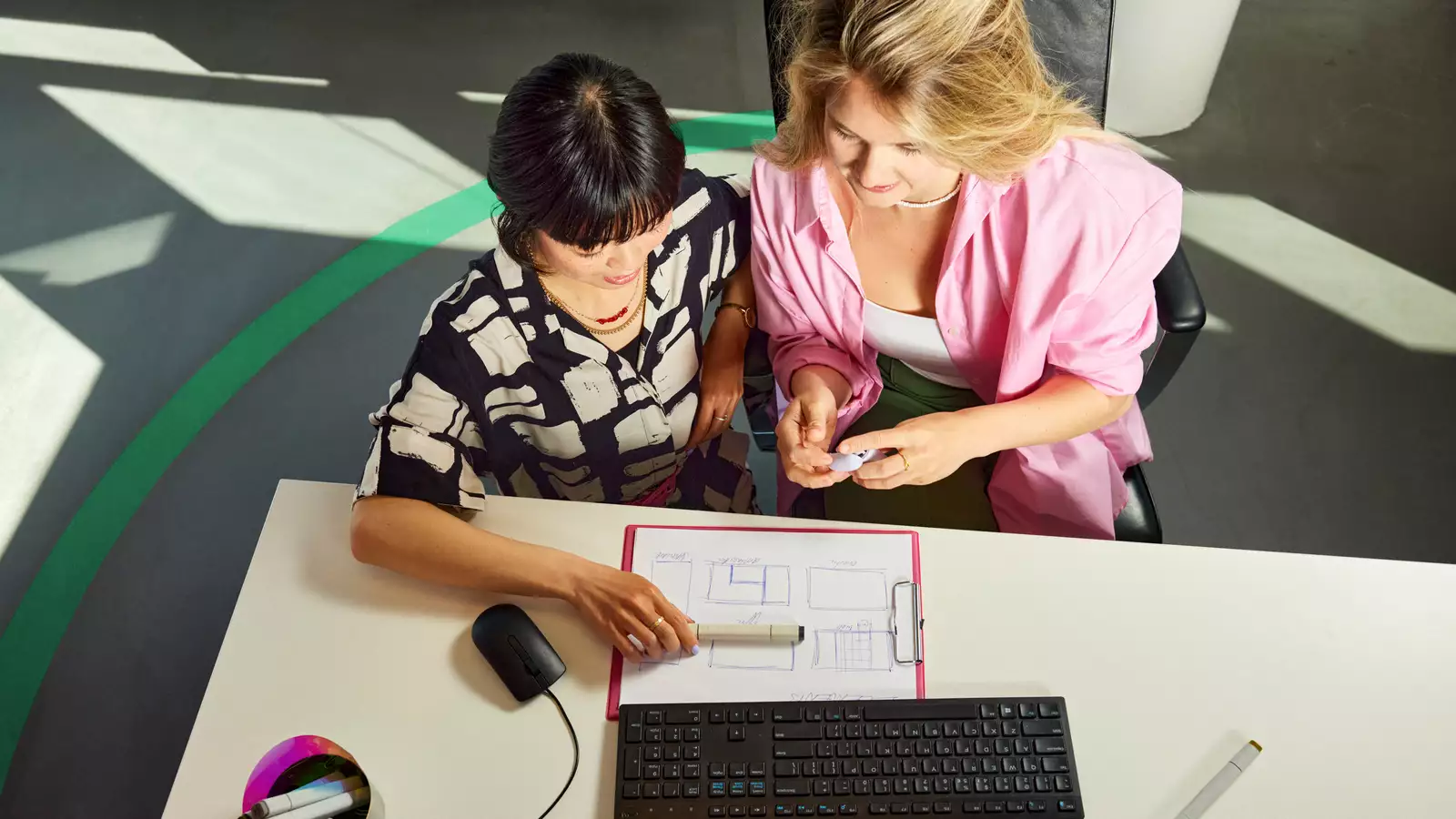 Twee vrouwen zitten aan een bureau