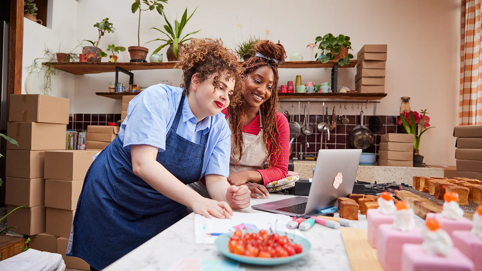 twee vrouwen achter laptop in keuken