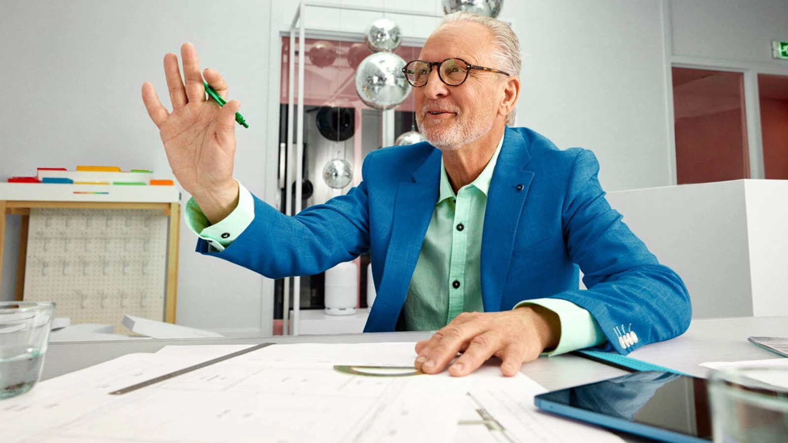 Man met een pen in zijn hand aan een bureau die stop seint.