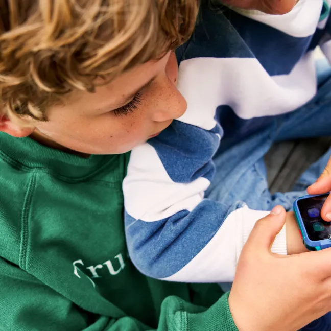 Twee kinderen kijken op een telefoonscherm. Twee kinderen kijken op een telefoonscherm.