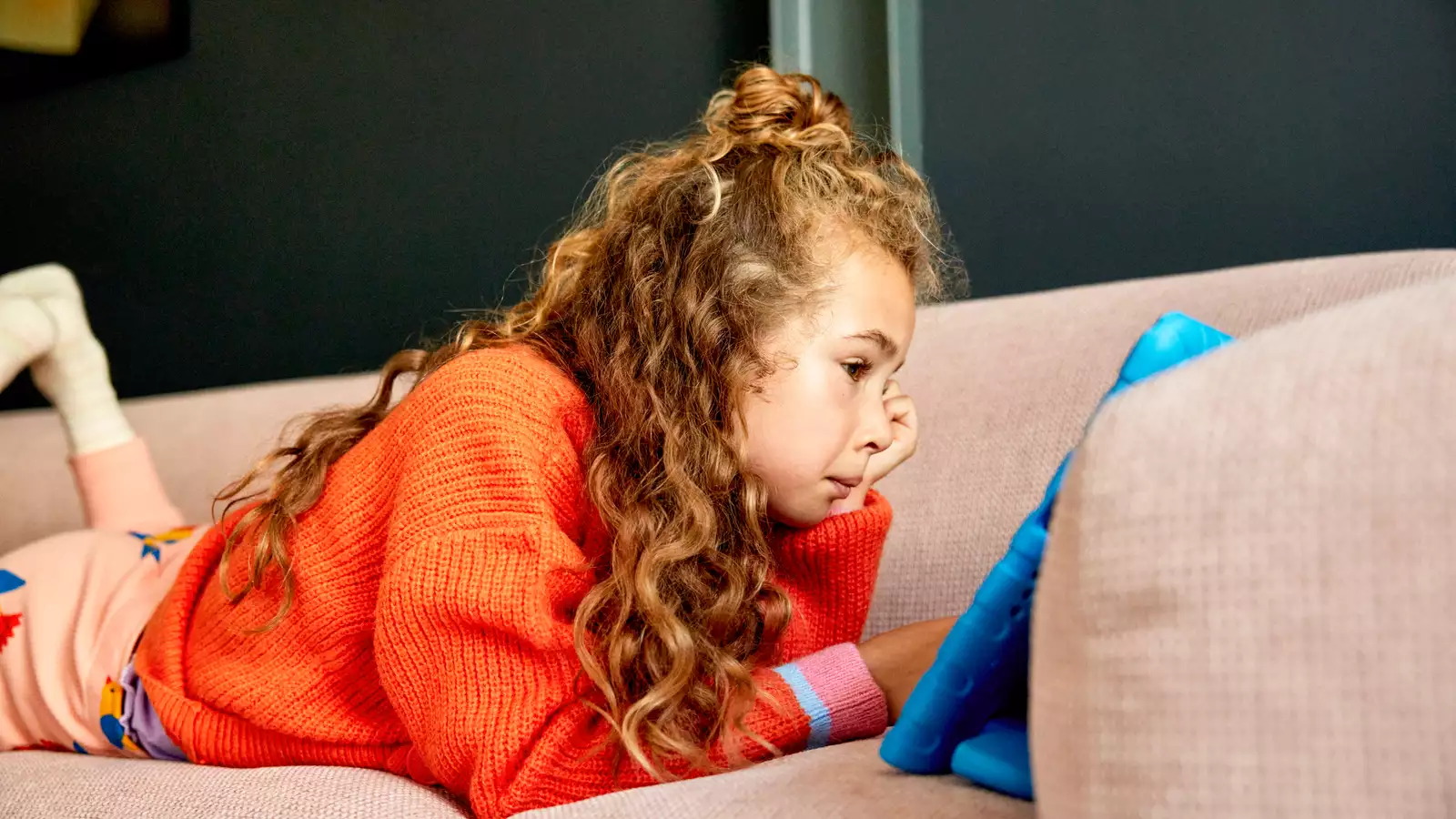 Kind speelt op bank met tablet