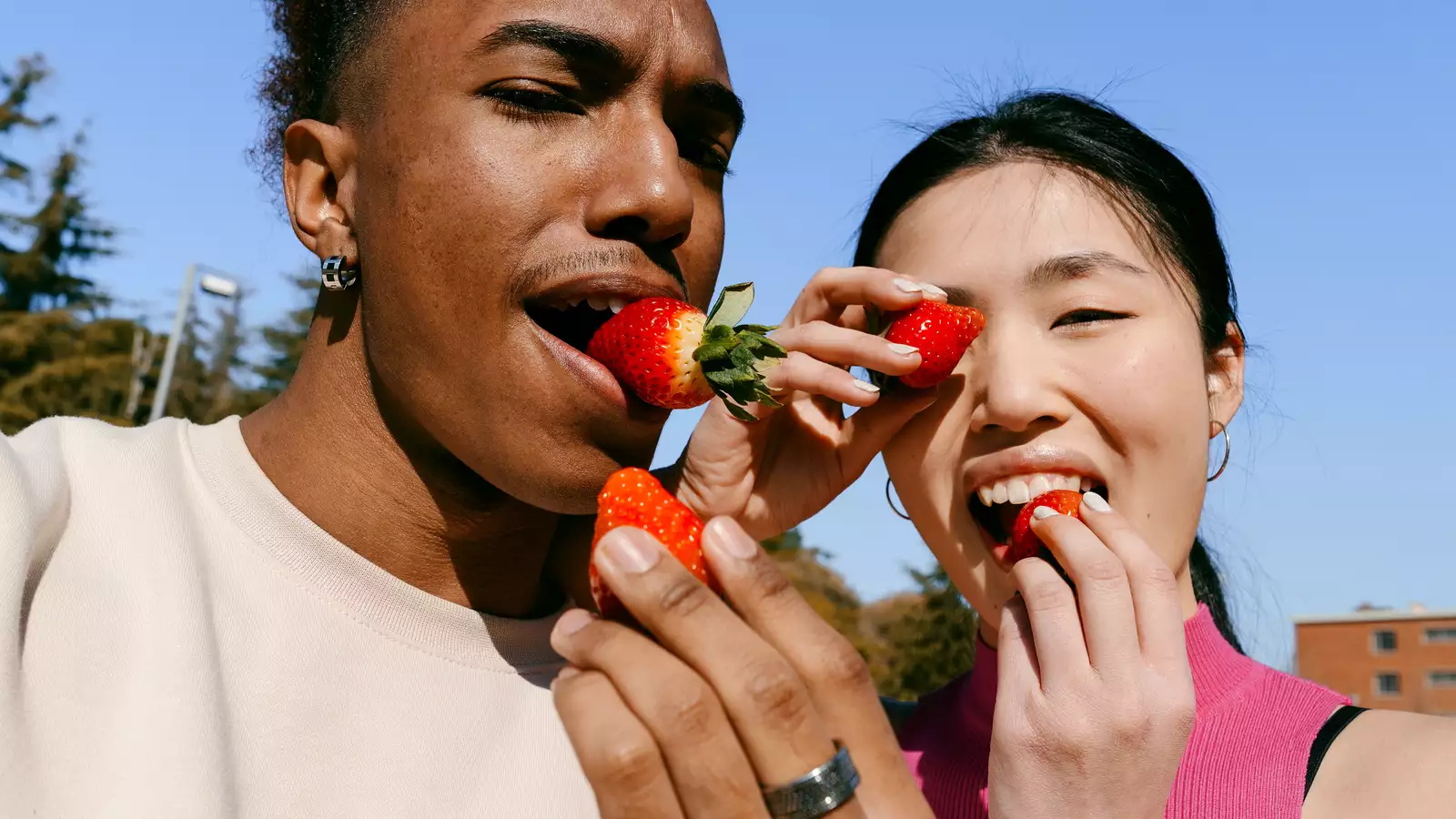 man en vrouw eten aardbeien