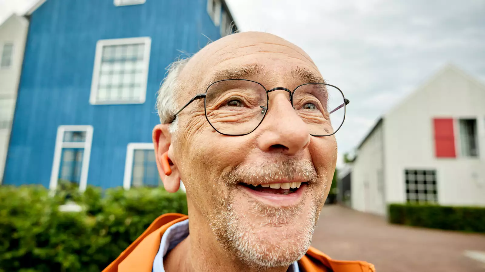 oudere meneer met oordopjes in zijn oren